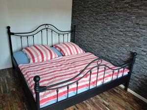 ein Bett mit zwei rot-weiß gestreiften Kissen in der Unterkunft Welschbach in Illingen + 2 Fotos