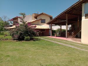 a house with a grass yard and a building at Refúgio do Jaguari in Piracaia