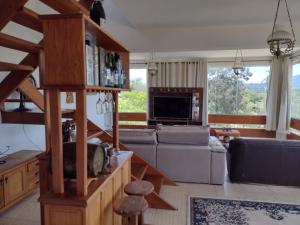 a living room with a couch and a tv at Refúgio do Jaguari in Piracaia
