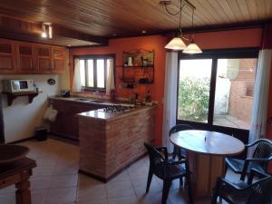 a kitchen with a counter and a table with chairs at Refúgio do Jaguari in Piracaia