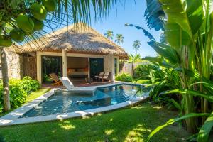 a swimming pool in a backyard with a hut at NANNAI Milagres in São Miguel dos Milagres