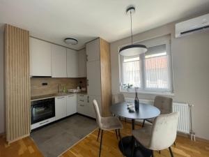 a kitchen and dining room with a table and chairs at Apartman Laki in Bijeljina