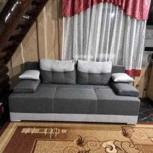a gray couch sitting in front of a window at Горянка in Oryava
