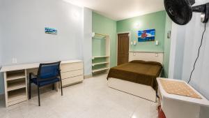 a bedroom with a bed and a desk and a chair at La Casa Ucraniana in Canoa