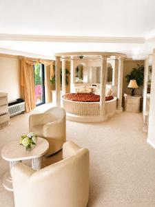 a large bedroom with a bed and a table and chairs at Chateau Royale Inn in Lake Geneva