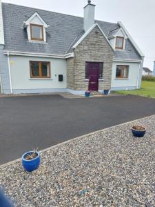 a house with two blue bowls in front of a driveway at Levally hs mountrivers doonbeg co clare 