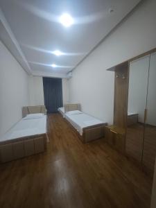 an empty room with two beds and a mirror at Baxt Hotel&Hostel in Andijan