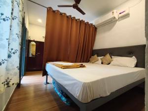 a bedroom with a bed with a ceiling fan at CloudHill Retreat in Ariankāvu