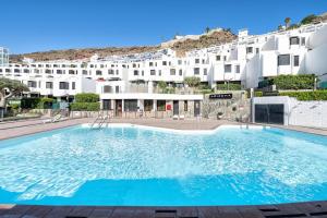 a large swimming pool in front of a building at Casa Arizona Central Duplex Puerto Rico GC in Mogán