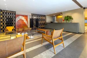 a library with chairs and tables and bookshelves at Intercity Faria Lima Address in São Paulo