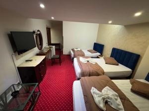 a hotel room with four beds and a flat screen tv at Verssailles Al Manar Hotel in Cairo
