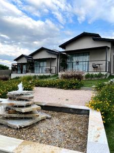a house with a fountain in front of a house at Angatu Chalés in Serra Negra