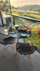 a table with a tray of food on a balcony at Angatu Chalés in Serra Negra