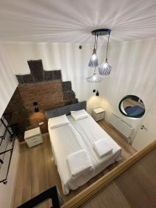 a bedroom with a white bed and a mirror at Communa Guesthouse in Gyumri