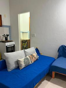 a blue couch with two pillows in a living room at Refúgio a 100m da Praia Conforto e Lazer Completo in Prado +8 photos