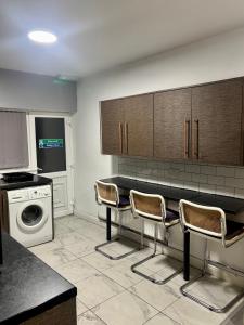 a kitchen with a washing machine and chairs in it at HomesRentals in Dudley