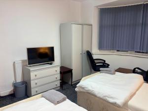 a room with two beds and a tv on a dresser at HomesRentals in Dudley
