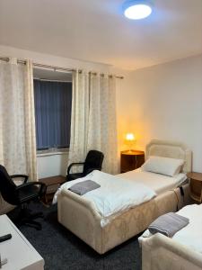 a room with two beds and a desk and chairs at HomesRentals in Dudley