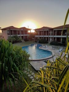 a resort with a swimming pool in front of a building at Ondas do mar Taiba Residence in Taíba