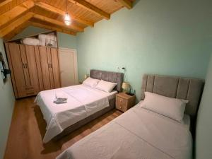 a bedroom with two beds and a wooden ceiling at Villa Bushati in Tropojë