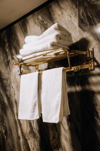 a towel rack with white towels on it at Avenue Nizami hotel in Baku +267 photos