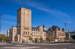 a large building with a clock tower in front of it at Self check-in Apartament Poznań Marcelin Lotnisko Ławica Szpitale Uczelnie in Poznań