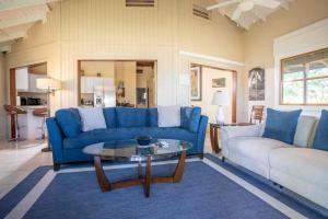 a living room with a blue couch and a table at Tres Amigos Beach House, Rincon PR in Rincon