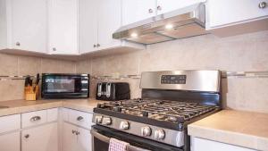 a kitchen with a stove and a microwave at Tres Amigos Beach House, Rincon PR in Rincon