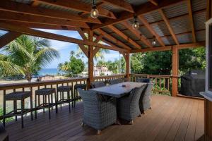a wooden deck with a table and chairs at Tres Amigos Beach House, Rincon PR in Rincon