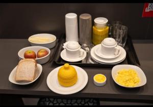 a tray with plates of food on a table at Luxus Motel Caldas do Jorro in Tucano