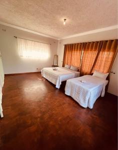 a hotel room with two beds and a window at BillGates BNB in Harare