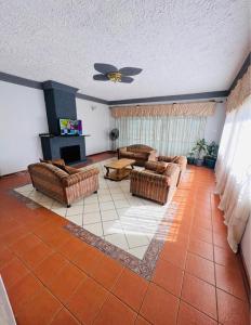a large living room with couches and a fireplace at BillGates BNB in Harare
