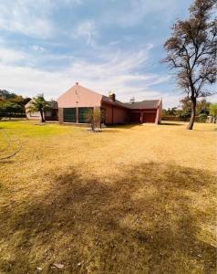 a large yard with a house and a tree at BillGates BNB in Harare