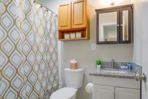 a bathroom with a toilet and a sink and a mirror at Tiger Town Retreat: Spacious 3-Home Retreat! in Baton Rouge +37 photos