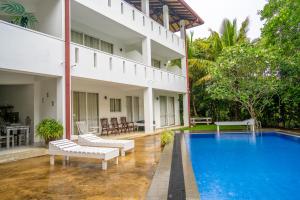 a villa with a swimming pool and a resort at Jippie The Villa in Hikkaduwa