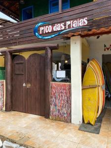 a pizza shop with a surfboard outside of it at Pico das Praias Suites in Itacaré