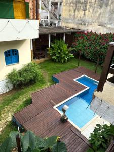 a backyard with a wooden deck and a swimming pool at Pico das Praias Suites in Itacaré