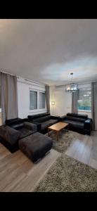 a living room with black couches and a table at 7- Bedroom Villa in Sarajevo