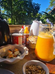 a table with food and a jar of orange juice at Pousada Recanto Afetivo in Trindade +17 photos
