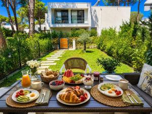 a table with breakfast foods on it in a backyard at San Pietro Premium Meliá Garden Apartment in Lalzit Bay