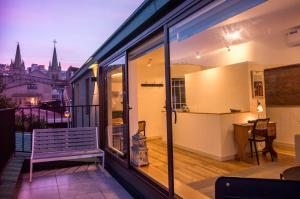 a balcony with a bench and a view of a city at Departamento San Enrique in Valparaíso