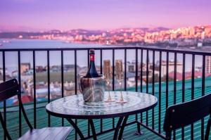 a bottle of wine sitting on a table on a balcony at Departamento San Enrique in Valparaíso