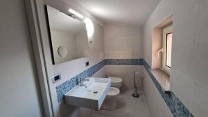 a bathroom with a sink and a toilet and a mirror at Il cedro blu in Santa Maria del Cedro +27 photos
