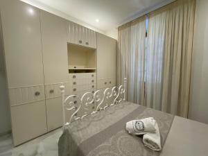 a bedroom with a white bed with towels on it at Apartment Palacio de Los Vibora Parking Gratis in Lucena