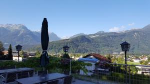 a patio with tables and an umbrella and mountains at Gasthof Bad Sonnenberg in Nüziders +16 photos