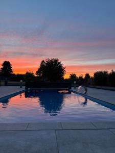 a swimming pool with a sunset in the background at Premium Apartment near Cologne in Hürth
