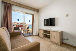 a living room with a couch and a flat screen tv at Marina Beach Apartaments - Sea views in the heart of Lloret in Lloret de Mar