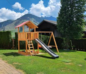 a playground with a slide and a play house at Prünsterhof in Obertilliach