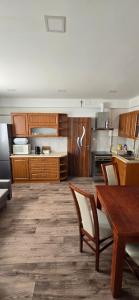 a kitchen with wooden cabinets and a table with chairs at Apartament WLA in Barcice +10 photos