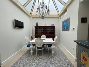 a dining room with a table and chairs and a chandelier at Apartment Palacio de Los Vibora Parking Gratis in Lucena